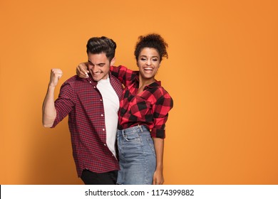 Studio Shot Of Happy Casual Mixed Race Couple Embracing, Posing To Camera And Smiling .