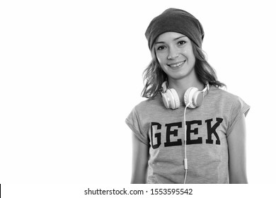 Studio shot of happy geek girl smiling with headphones around neck