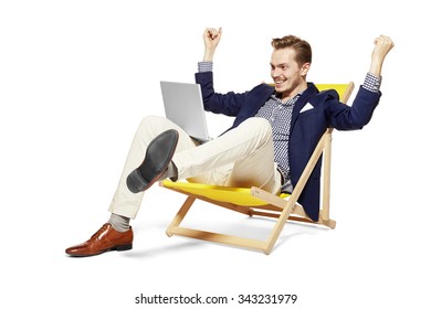 Studio shot of happy young man sitting on sunbed. He raises his arms in a gesture of victory. - Powered by Shutterstock