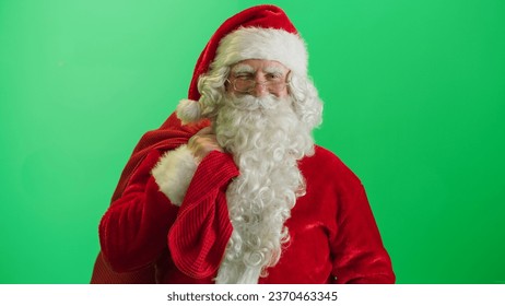 Studio Shot Isolated Mockup Template: Jolly Santa Claus Standing On Green Screen Chromakey Background With Hands Crossed, Looks At the Camera And Winks. Christmas, New Year, Holiday Celebration - Powered by Shutterstock