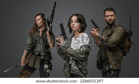 Studio shot of isolated on gray background three post apocalyptic survivors.