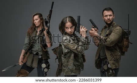 Studio shot of isolated on gray background three post apocalyptic survivors.
