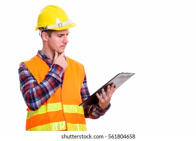 Studio Shot Of Man Construction Worker Reading On Clipboard While Thinking