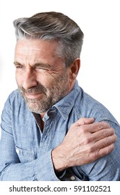 Studio Shot Of Man Suffering With Frozen Shoulder