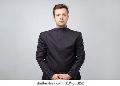 Studio Shot Of A Mature Caucasian Man Wearing His Suit On Backwards, Gray Background. He Lost His Mind From Continuous Work. Obvious Mental Problems