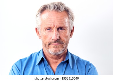 Studio Shot Of Mature Man With Serious Expression Against White Background At Camera