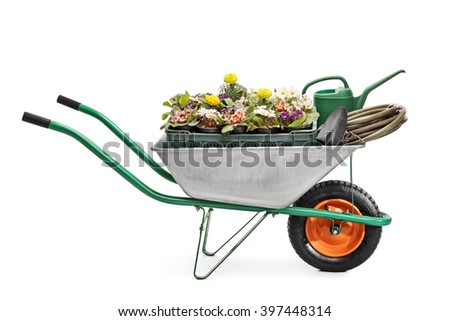 Studio shot of a metal wheelbarrow full of gardening equipment and flowers isolated on white background