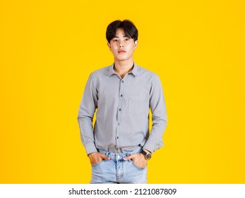 Studio Shot Of Millennial Asian Young Male Fashion Model In Stylish Fashionable Casual Outfit Standing On Yellow Background