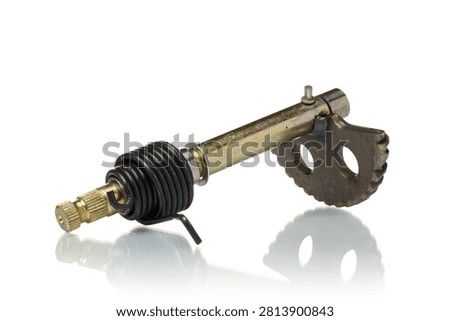 Studio shot of a new motorcycle engine kickstarter shaft spindle assembly isolated on a white background. High-quality moped or pit bike transmission linkage component featuring a gold-tone anodized steel splined shaft assembly equipped with a heavy-duty black torsion return spring and a welded semi-circular kick start gear segment sector with dual weight-reduction holes. High-key product photography with reflection.
