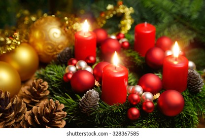 Studio shot of a nice advent wreath with baubles and three burning red candles