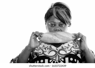 Studio Shot Of Overweight African Woman Eating Bread