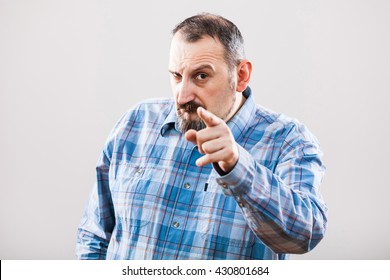 Studio shot portrait of angry man pointing