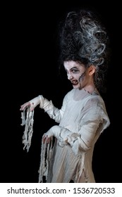 Studio Shot Portrait Of Young Girl In Costume Dressed As A Halloween, Cosplay Of Scary Bride Of Frankenstein Pose On Isolated Black Background