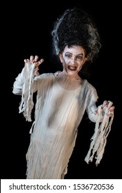studio shot portrait of young girl in costume dressed as a Halloween, cosplay of scary bride of Frankenstein pose on isolated black background
