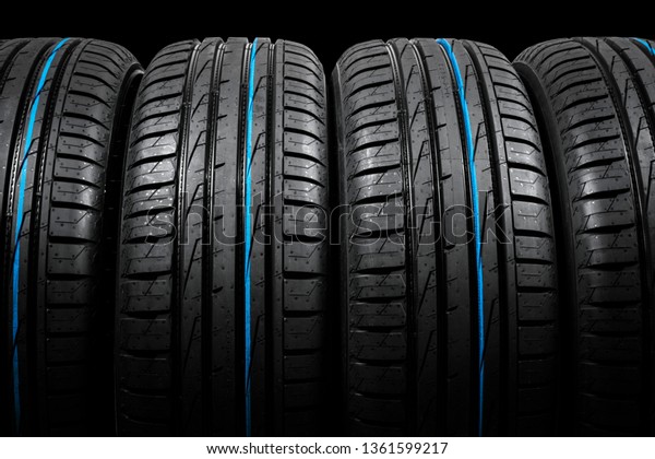 Studio shot set of a summer car tires on black
background. Tire stack background. Car tyre protector close up.
Black rubber tire. Brand new car tires. Close up black tyre
profile. Car tires in a
row