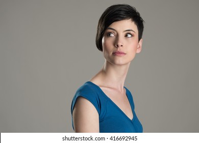 Studio Shot Of Short Hair Beauty Model Looking Back Over The Shoulder With Copyspace Over Gray Background