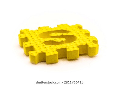 Studio shot of a single yellow soft interlocking foam puzzle mat showing the letter S on a plain white background