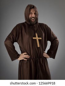 Studio Shot Of A Slightly Overweight Man Wearing A Monk Robe, Laughing While Looking At Camera.