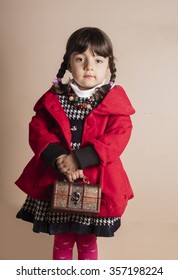 Studio Shot Of Small Iraqi Girl With Red Coat Holding Wooden Box 