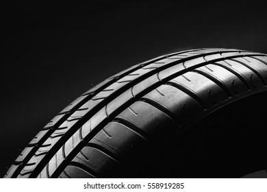 Studio shot of a summer, fuel efficient car tire on black background. Contrasty lighting and shallow depth of field