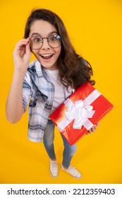 Studio Shot Of Surprised Teen Girl Hold Present. Teen Girl Holding Box Of Present. Teen Girl