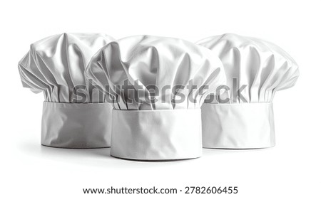 A studio shot of three classic white chef hats, also known as toque blanches, displayed together on a clean white surface.