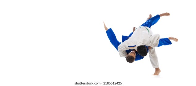 Studio Shot Of Two Men, Professional Judo Athletes Training Isolated Over White Background. Sweeping Hip Throw. Concept Of Martial Art, Combat Sport, Health, Strength, Energy. Copy Space For Ad, Flyer