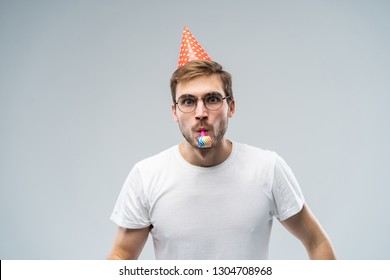 Studio shot of unshaven young Caucasian male blowing whistle while celebrating birthday, having relaxed and cheerful expression on his face. - Shutterstock ID 1304708968
