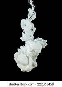 Studio shot of white ink in water, isolated on black background