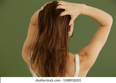 Studio Shot Of Woman Applying Hair Oil With Her Fingers