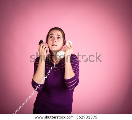 Studio shot of a woman on a pink background with a vintage corded phone having a conversation