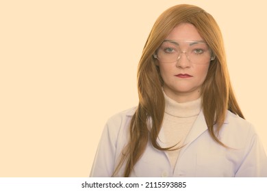 Studio Shot Of Woman With Red Hair Against Plain Background