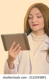 Studio Shot Of Woman With Red Hair Against Plain Background