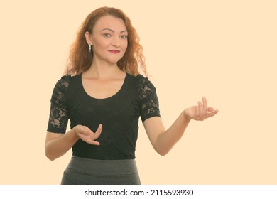 Studio Shot Of Woman With Red Hair Against Plain Background