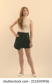 Studio Shot Of Woman With Red Hair Against Plain Background