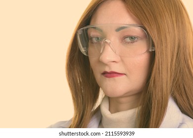 Studio Shot Of Woman With Red Hair Against Plain Background