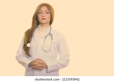 Studio Shot Of Woman With Red Hair Against Plain Background