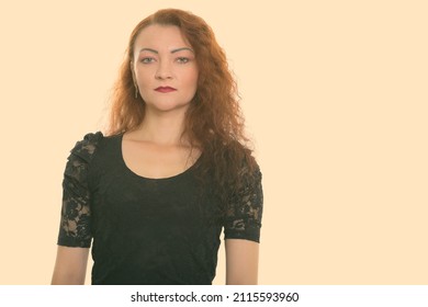 Studio Shot Of Woman With Red Hair Against Plain Background