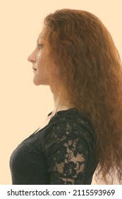 Studio Shot Of Woman With Red Hair Against Plain Background