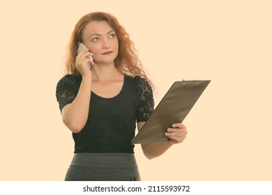 Studio Shot Of Woman With Red Hair Against Plain Background