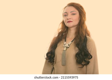 Studio Shot Of Woman With Red Hair Against Plain Background