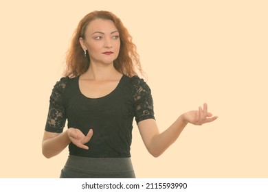 Studio Shot Of Woman With Red Hair Against Plain Background