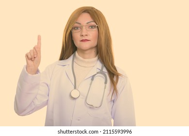 Studio Shot Of Woman With Red Hair Against Plain Background