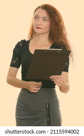 Studio Shot Of Woman With Red Hair Against Plain Background