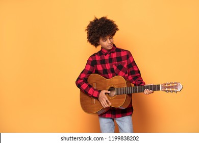 Studio Shot Of Young African Teenage Boy Posing With Guitar.