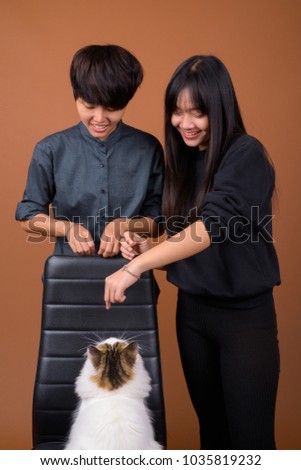 Studio shot of young Asian lesbian couple together and in love against brown background Studio Shot Young Asian Lesbian Couple Stock Photo (Edit Now ...
