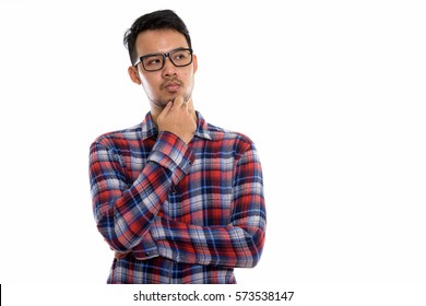 Studio Shot Of Young Asian Man Thinking While Wearing Eyeglasses