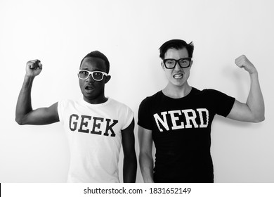 Studio Shot Of Young Black African Geek Man With European Nerd Man Flexing Arms And Showing Bicep Muscles