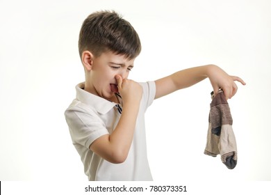 Studio Shot Of Young Boy Holding Stinky Sock