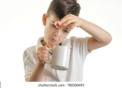 Studio Shot Of Young Boy Making Cup Of Tea - Healthy Eating Habits Concept